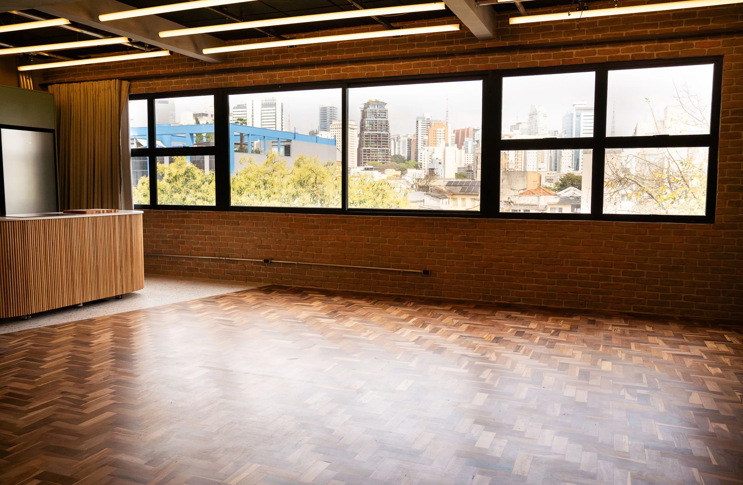 Loft com tijolo, madeira e luz natural.