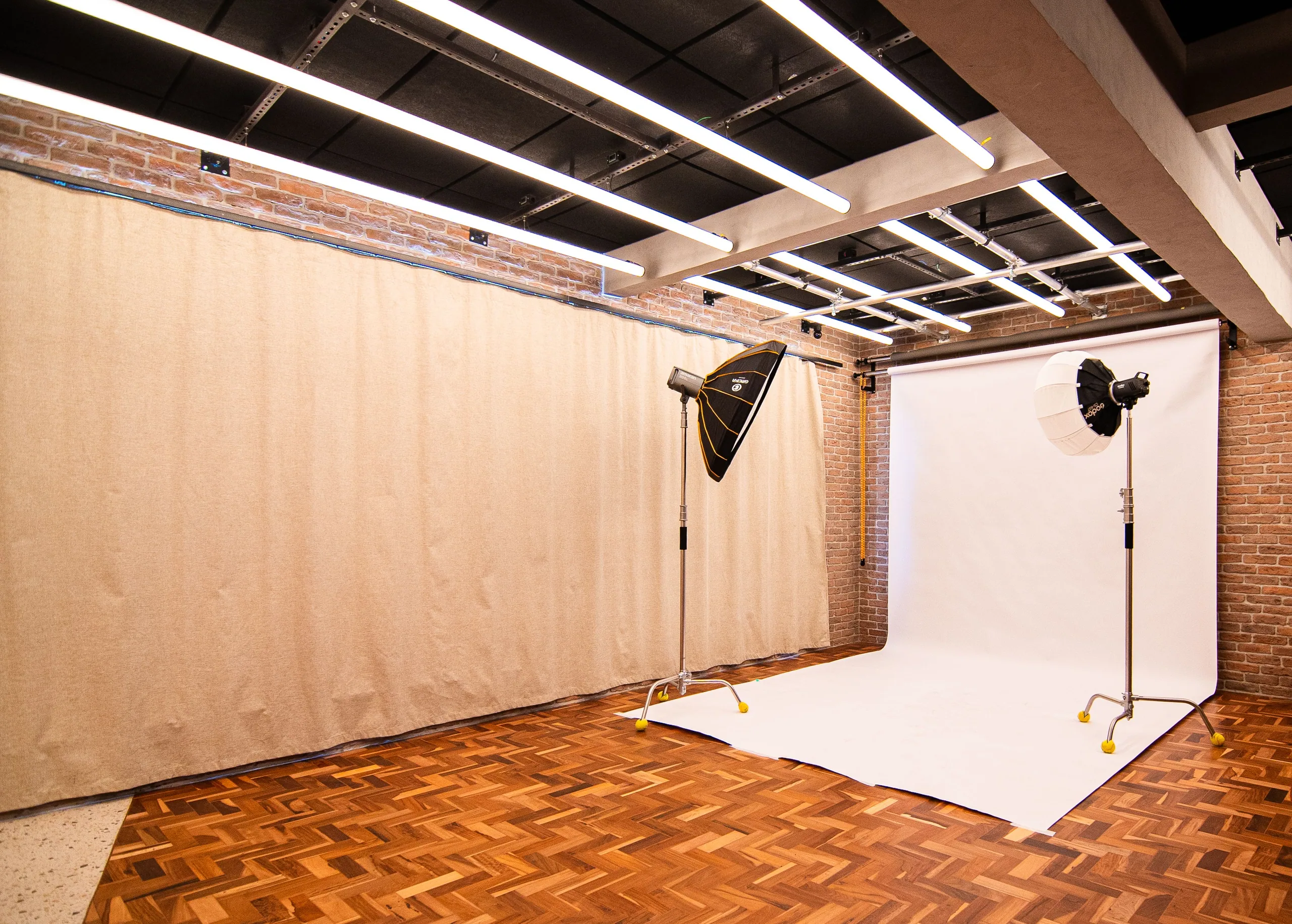 A set rigged in the Loft before the shoot: a white infinity backdrop, two flash heads with softboxes, the blackout drawn and the lighting grid on.