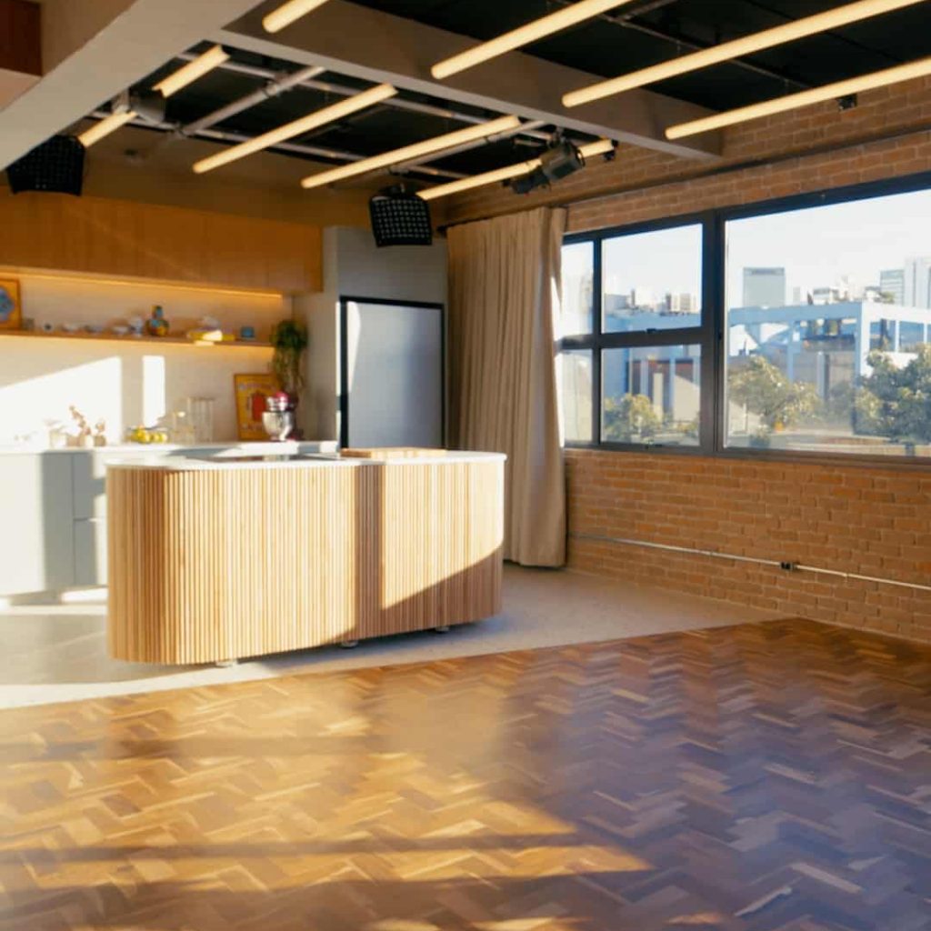 Studio de criativo com iluminação moderna, janelas grandes e piso de madeira, ideal para eventos e produções no centro de São Paulo.