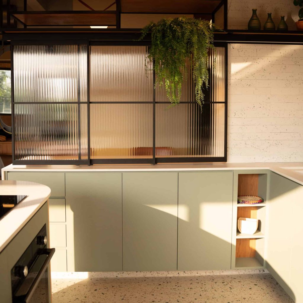 Quarto de cozinha com móveis em estilo minimalista, iluminação natural e elementos em verde, criando um ambiente aconchegante e funcional no Espaço Híbrido.